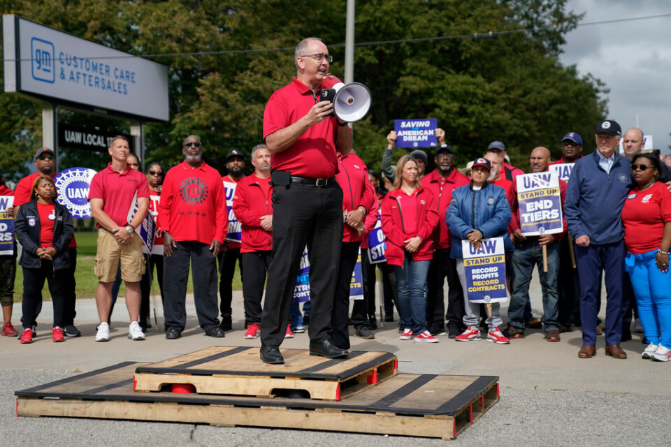 UAW:s ordförande Shawn Fain leder strejkprotester, med bland andra president Joe Biden som åhörare.