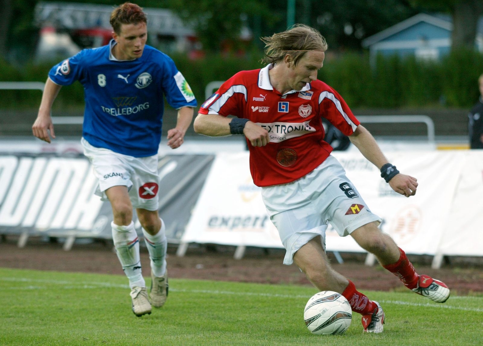 Vi tar oss vidare till 2003. Kalmar FF ställs mot Trelleborgs FF och Henrik Rydström försöker ta sig förbi Kristian Haynes. Lägg märke till hockeyfrillan!