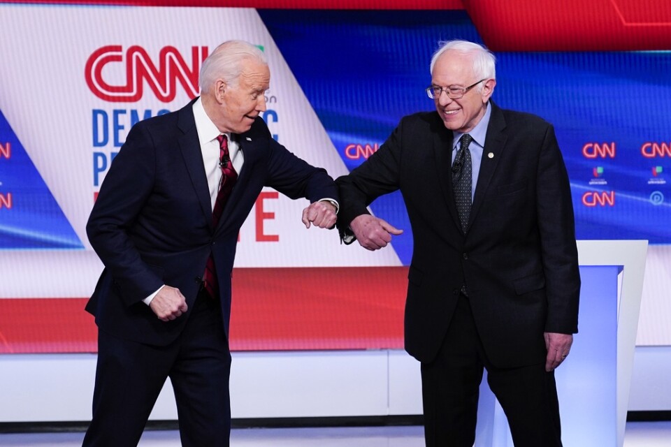 De demokratiska presidentaspiranterna Joe Biden, exvicepresident, och Bernie Sanders, Vermontsenator, armbågshälsar på varandra för att undvika eventuell virussmitta. Detta vid en tv-debatt i söndags.