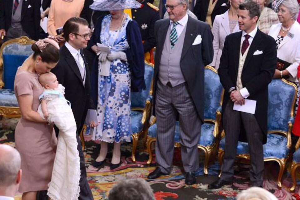 Kronprinsessan Victoria, prins Daniel ooch prinsessan Estelle lämnar prinsessan Estelles dopceremoni i Slottskyrkan på tisdagen. I bakgrunden drottning Margrethe, prins Henrik, kronprins Frederik och kronprinsessan Maxima.