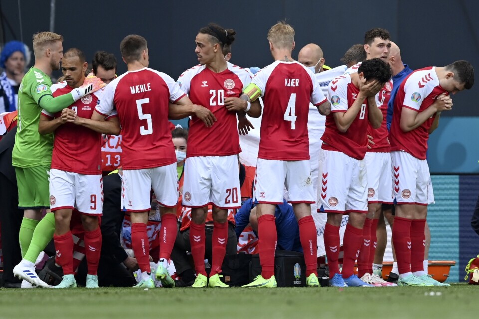 De danska spelarna bildar en mur runt Christian Eriksen när han fick behandling på planen i Köpenhamn.