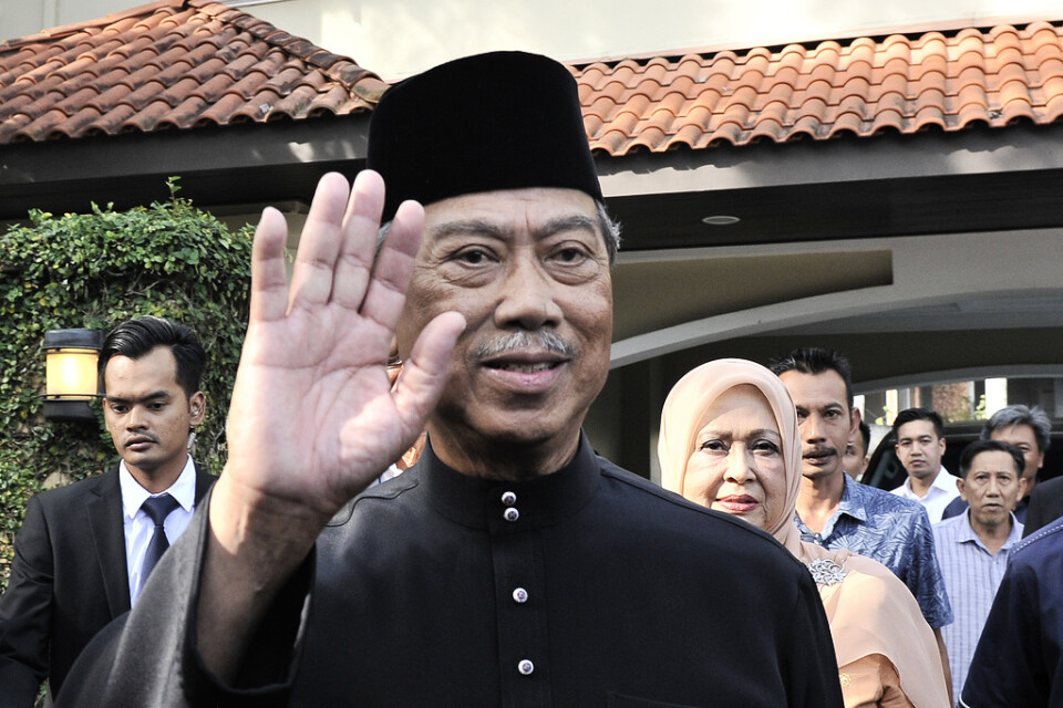 Muhyiddin Yassin vinkar på väg till palatset där han svors in som ny premiärminister i Malaysia.