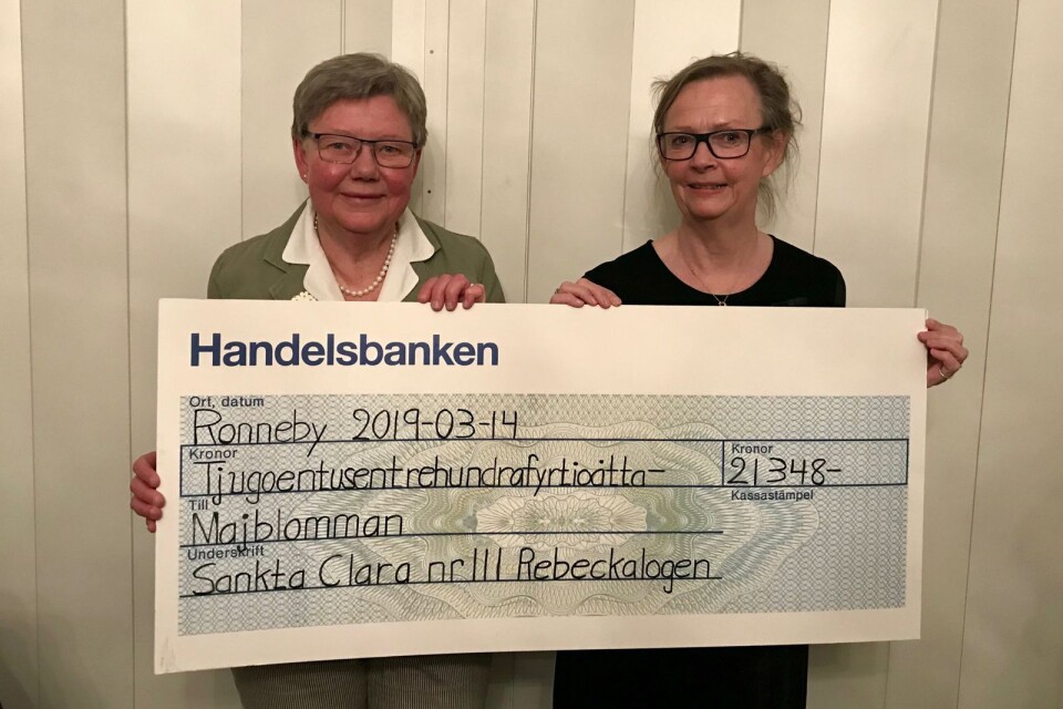 Övermästare Lena Kallberg-Larsson, till höger, överlämnar den symboliska checken till Majblommekommitténs ordförande Agneta Carlander.