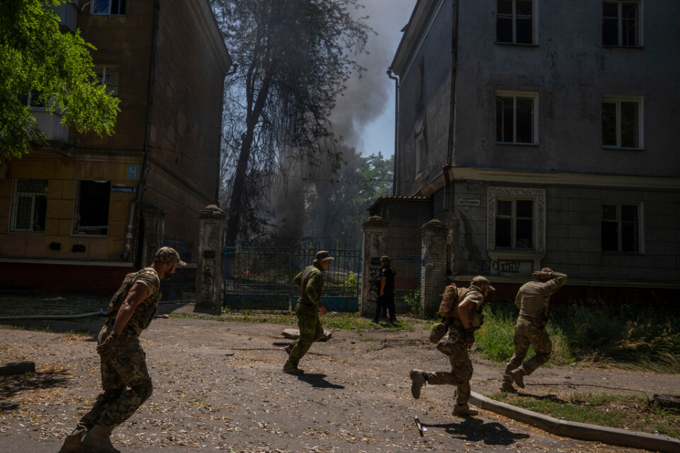 Ukrainska soldater söker skydd efter en attack mot ett bostadsområde i Kramatorsk i Donetsk.