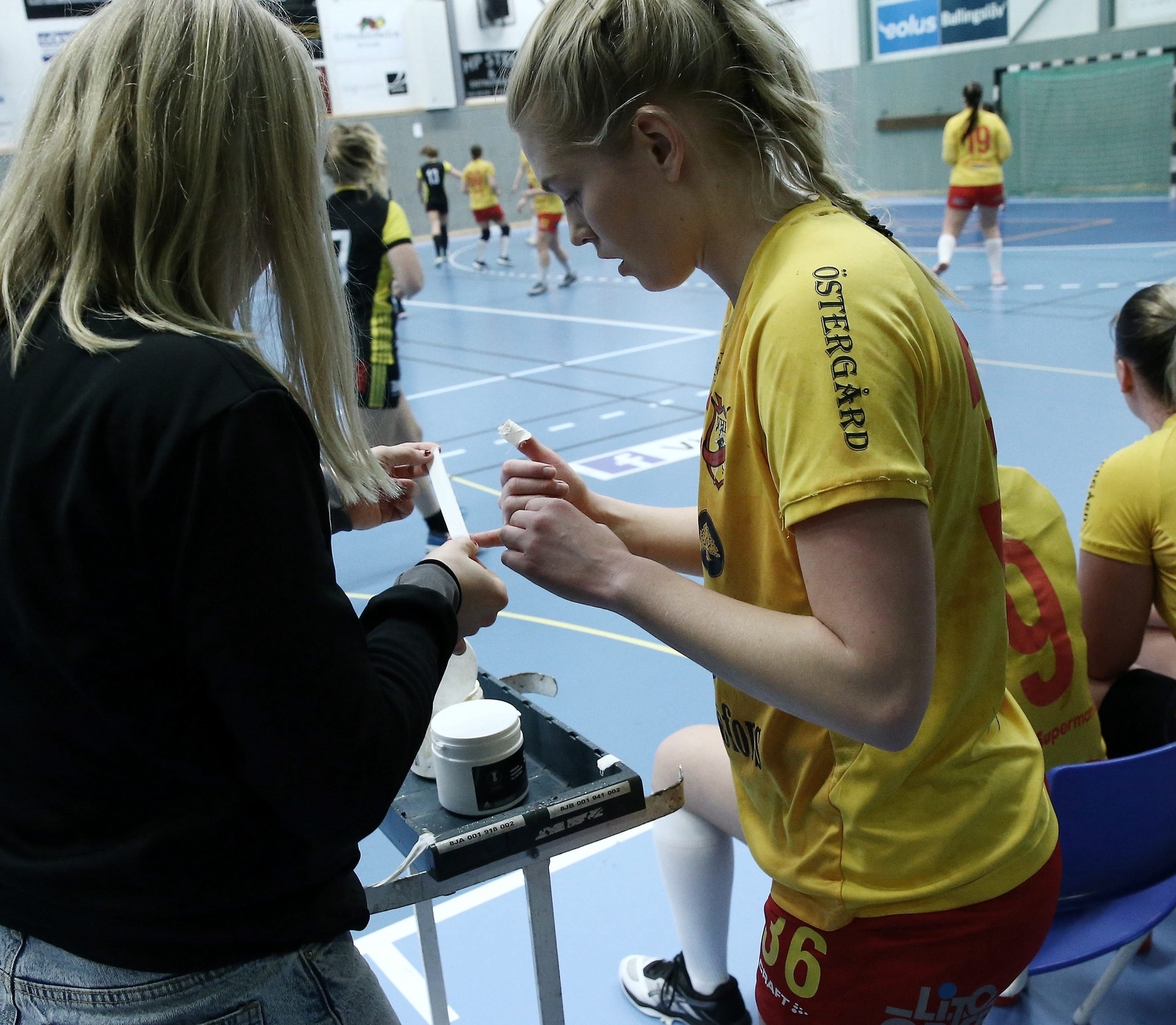 Elin Bagge får hjälp med att tejpa fingrarna under matchen mot Växjö. Foto: Stefan Sandström