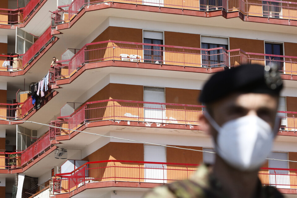En soldat framför ett flerfamiljshus där tiotals coronafall har rapporterats i regionen Kampanien.