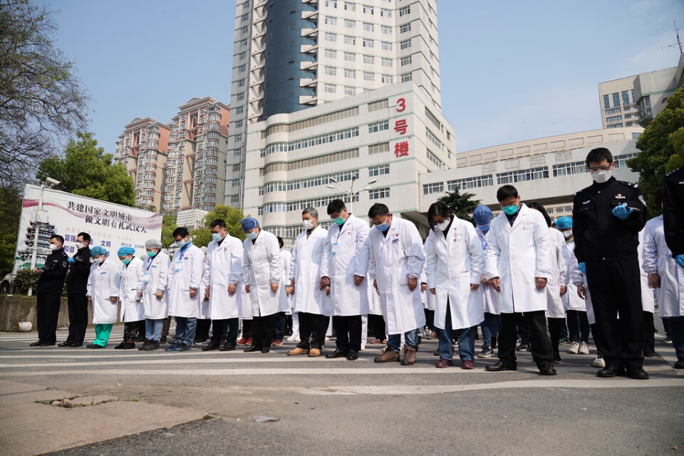 Sjukvårdspersonal i Wuhan under lördagens minnesstund.