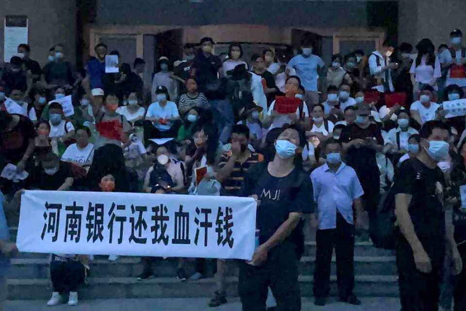 Demonstranter på trappan utanför en filial till Kinas centralbank i Zhengzhou i Henan-provinsen.