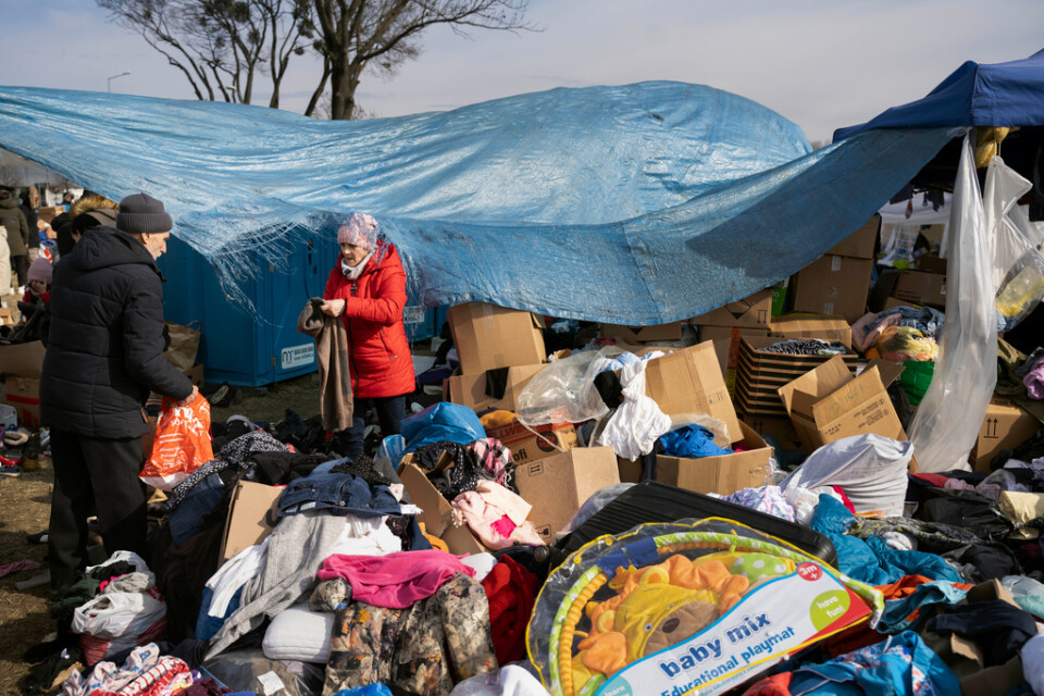 Flyktingar från kriget i Ukraina letar extrakläder vid gränsövergången Medyka i södra Polen på tisdagen, 1 mars, innan vidare färd.