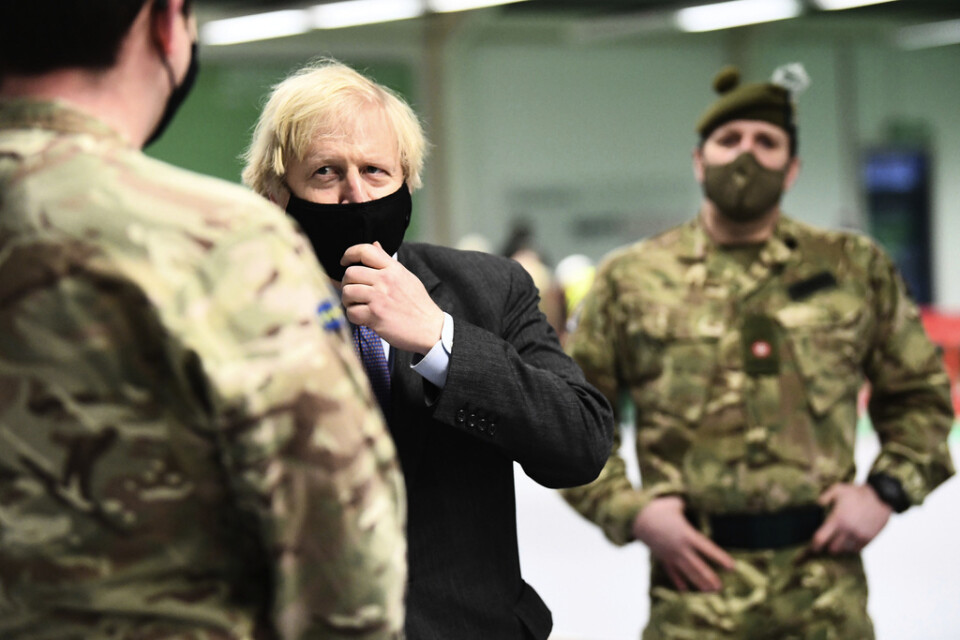 Storbritanniens premiärminister Boris Johnson träffar soldater som jobbar med att bygga upp ett vaccionationscenter i Glasgow i Skottland.