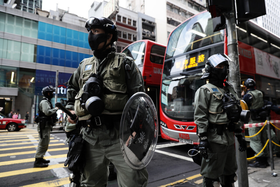 Polis vaktar en busshållsplats i Hongkong under måndagsmorgonen.