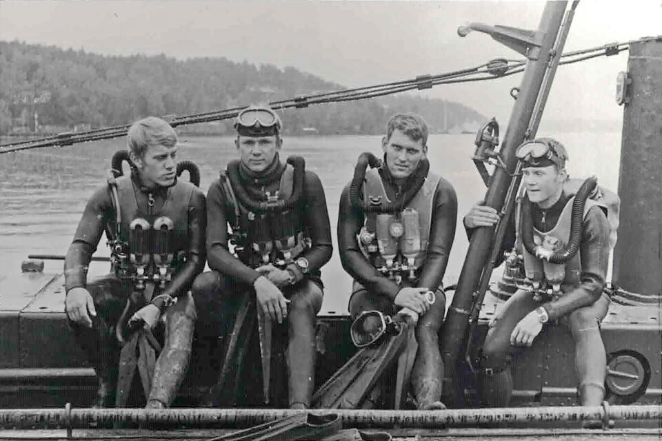 Några blivande attackdykare, sittande på miniubåten HMS Spiggen, under en övningspaus i slutet av 1960-talet. Utbildningsomgången som ryckte in 1968 var den sista som utbildades på Spiggen.