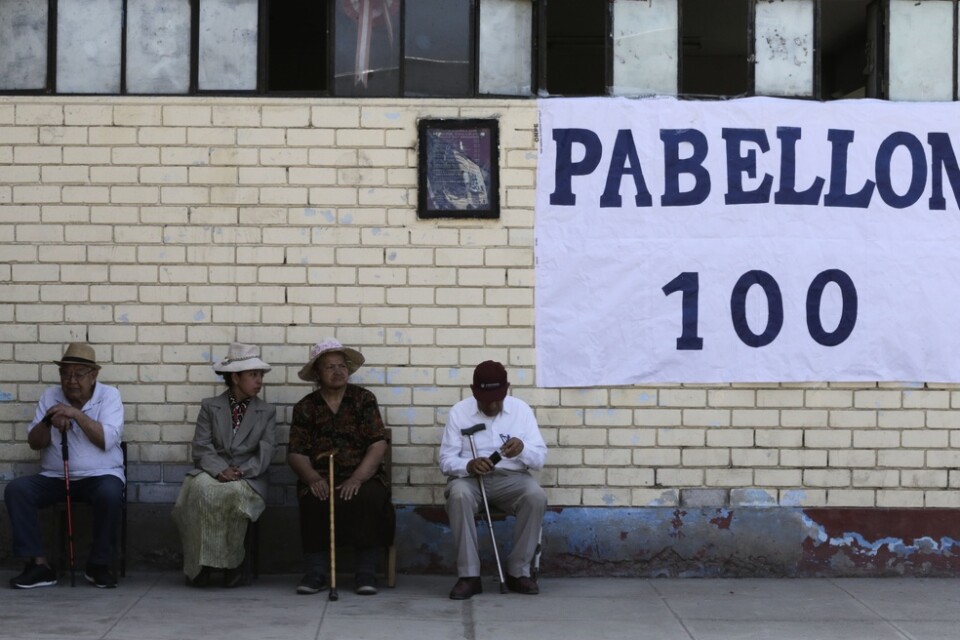 En grupp peruaner väntar på att rösta vid en skola i Lima.