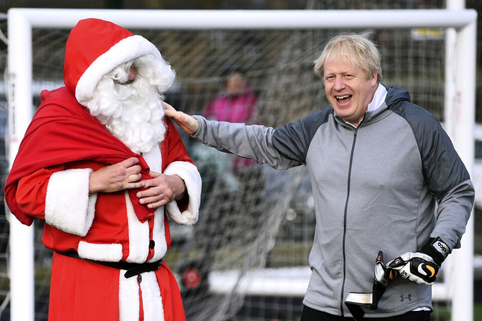 Storbritanniens premiärminister Boris Johnson hälsar på jultomten innan en fotbollsmatch som han besökte under ett stopp på sin valturné i Cheadle Hulme i lördags.