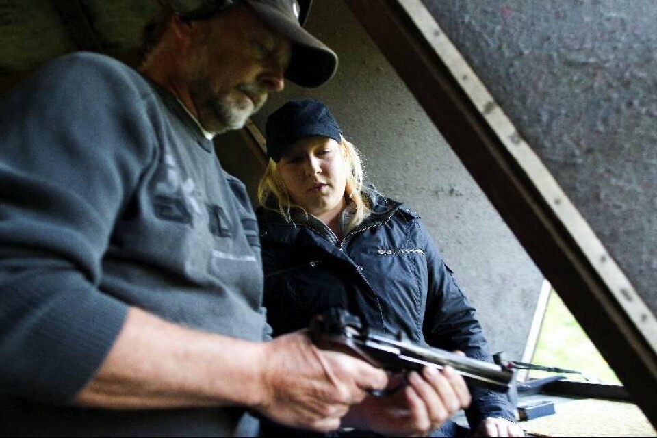 Caroline Nilsson har tagit över sin farfars pistol. Pappa Kjell som också är skytt kontrollerar pistolen.