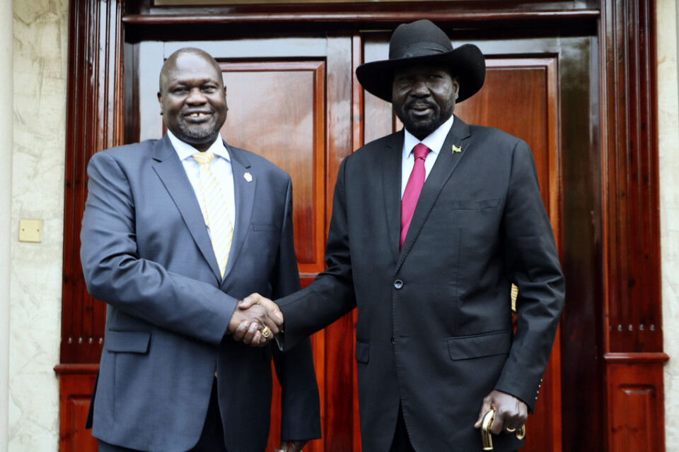 Riek Machar, till vänster, tar Sydsudans president Salva Kiir i hand under deras möte i Juba i måndags.