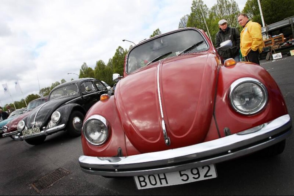 Sten Lignell från Trelleborg och Inge Åberg från Marieholm står och pratar bredvid en röd VW-bubbla från 1960 som ägs av Stens son Daniel Lignell. Foto: Tomas Nyberg