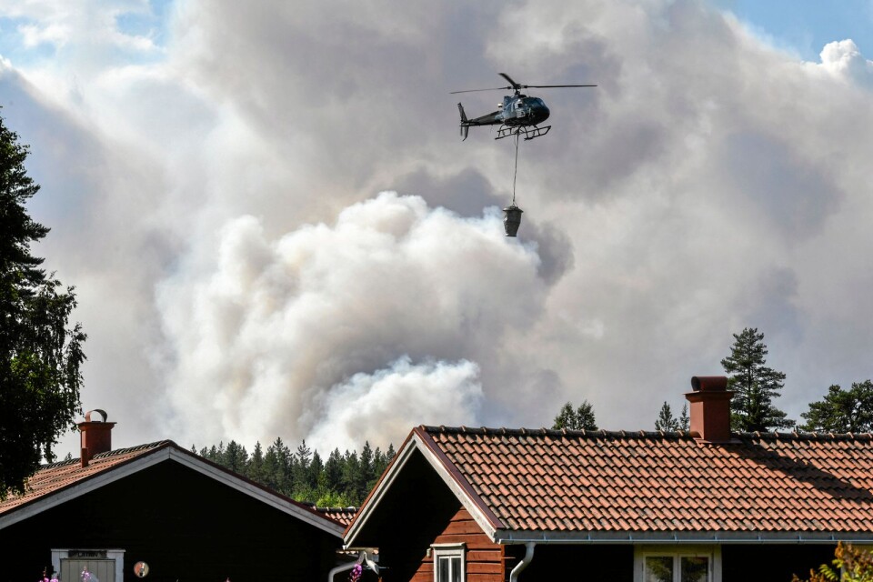 En helikopter hjälper till med släckningsarbetet vid en skogsbrand.