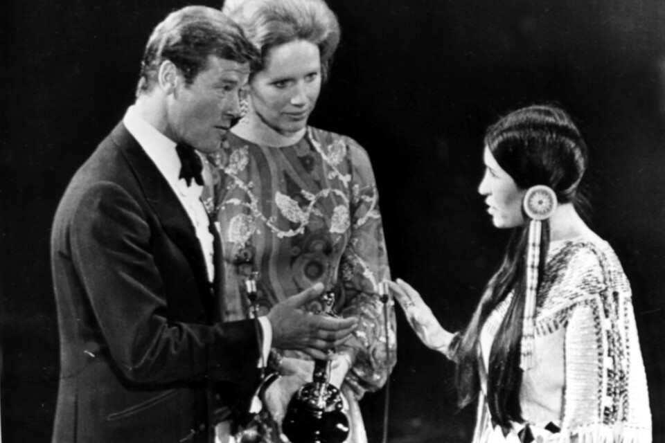 Sacheen Littlefeather tillsammans med prisutdelarna Roger Moore och Liv Ullmann på Oscarsgalan 1973.