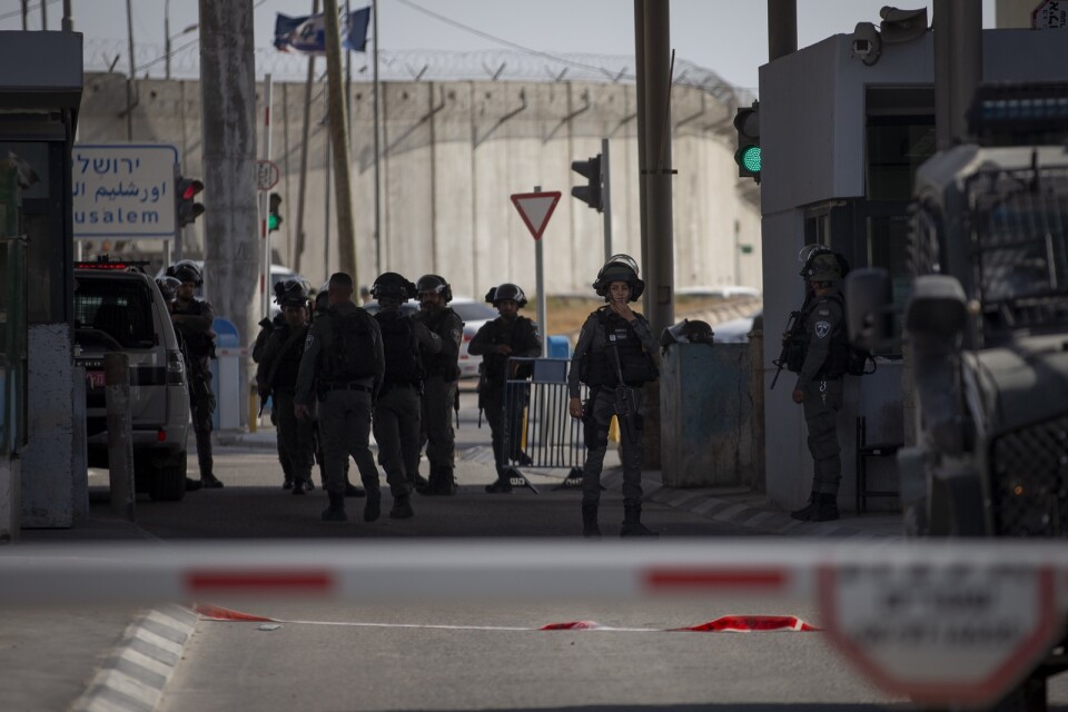 Israeliska soldater samlas vid den vägspärr mellan Jerusalem och Ramallah i Västbanken, där en kvinna sköts till döds efter att hon knivbeväpnad närmat sig gränsvakterna.