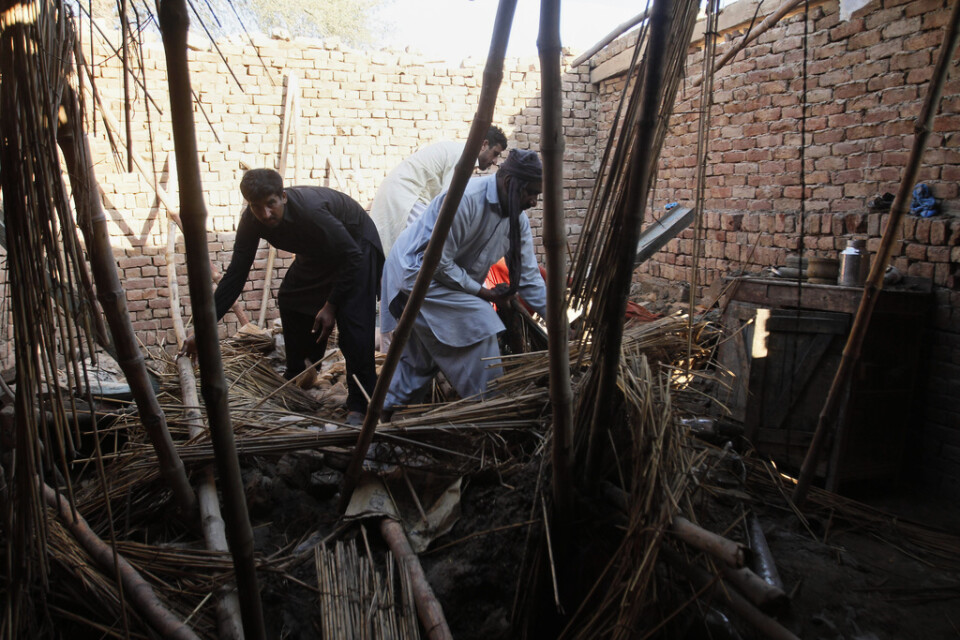 Bild från ett tidigare tillfälle. Boende i Multan, i östra Pakistan, letar efter sina tillhörigheter efter att taket på deras hus rasade in efter kraftiga regnfall. Bild från 21 februari.