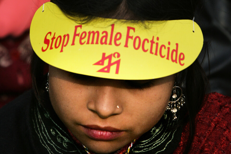 En kvinna deltar i en demonstration mot selektiva aborter på flickfoster i New Delhi, Indien. Arkivbild