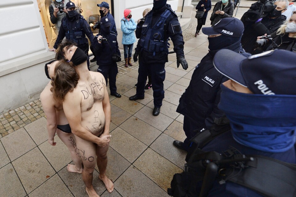 Poliser ingrep mot två aktivister som genomförde en demonstration för mänskliga friheter i Warszawa.