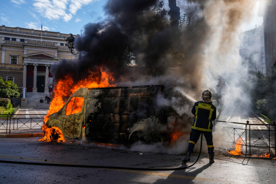 En brinnande bil i centrala Aten under onsdagens transportstrejk som äger rum runtom i Grekland.