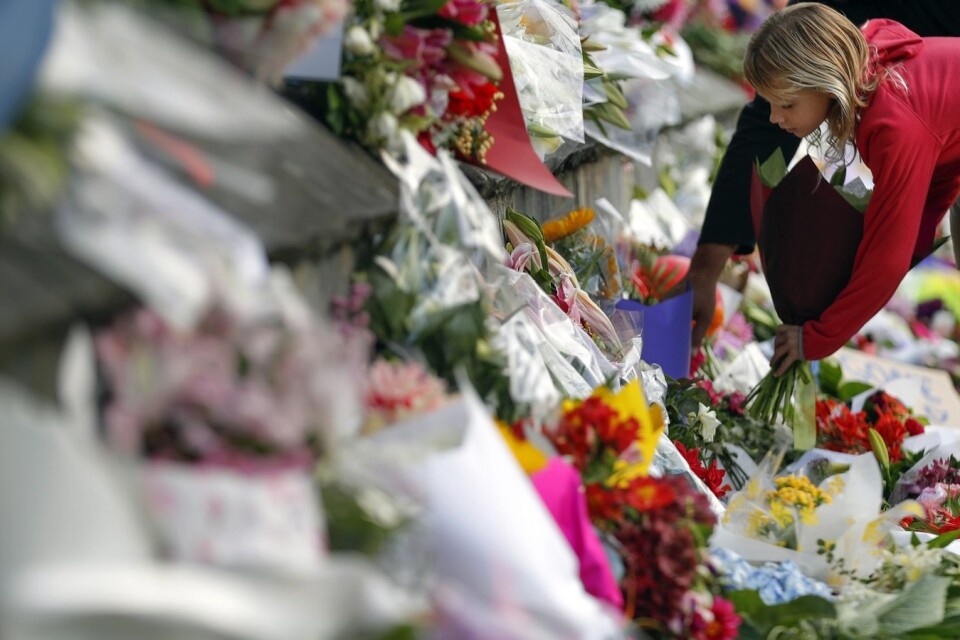 Sörjande lägger blommor för att hedra offrena i attackerna mot de två moskéerna i Christchurch, Nya Zeeland, där hitills 50 personer mist livet. Foto:  AP Photo/Vincent Thian