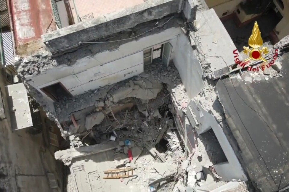 På räddningstjänstens bild syns hur en del av ett trevåningshus kollapsade utanför Neapel.