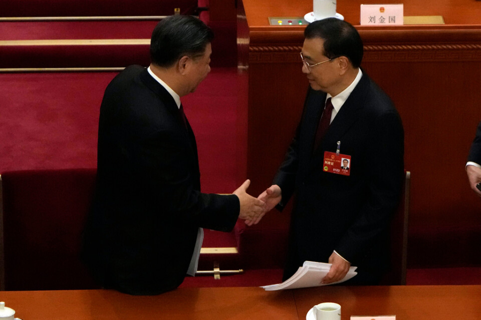 Kinas president Xi Jinping, till vänster, skakar hand med premiärminister Li Keqiang efter folkkongressens öppnande i Peking.