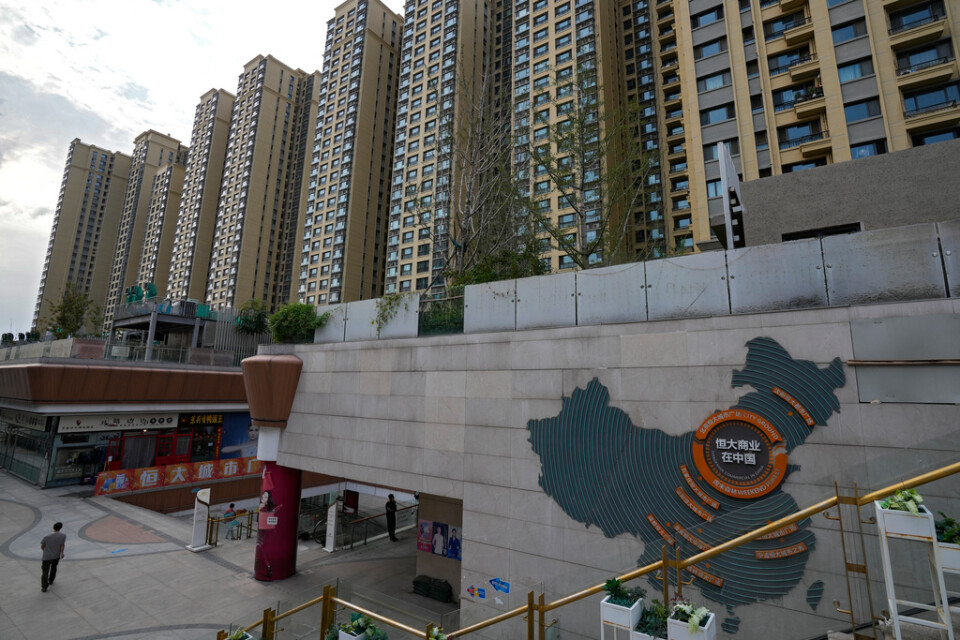 En karta över krisdrabbade Evergrandes fastighetsutvecklingsprojekt syns på en husfasad i ett köpcentrum i Peking med ett av koncernens bostadskomplex i bakgrunden.