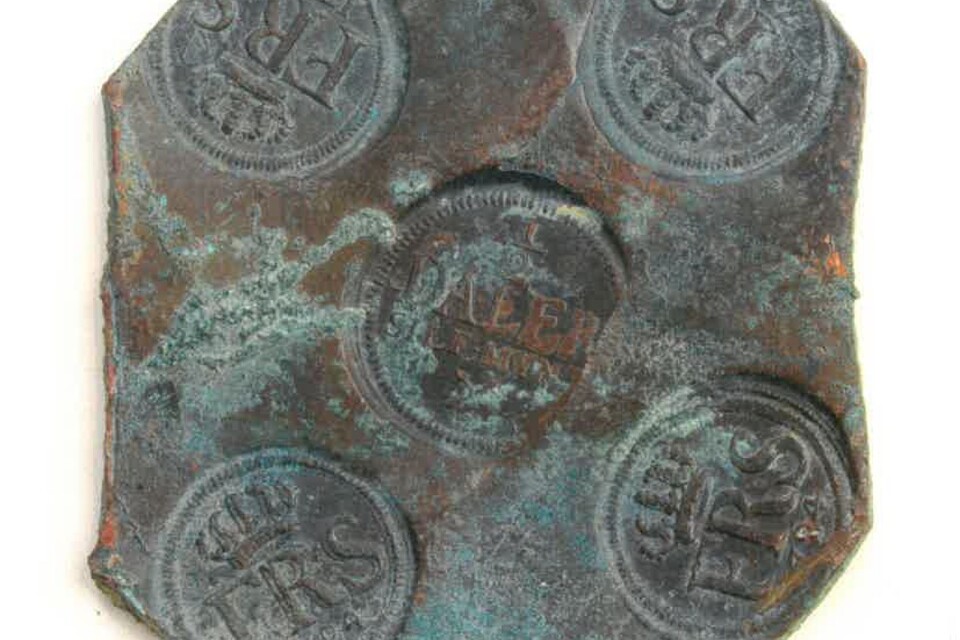 Ett av de 21 kopparplåtmynt som familjen i Kristianstad hittade på sin tomt.