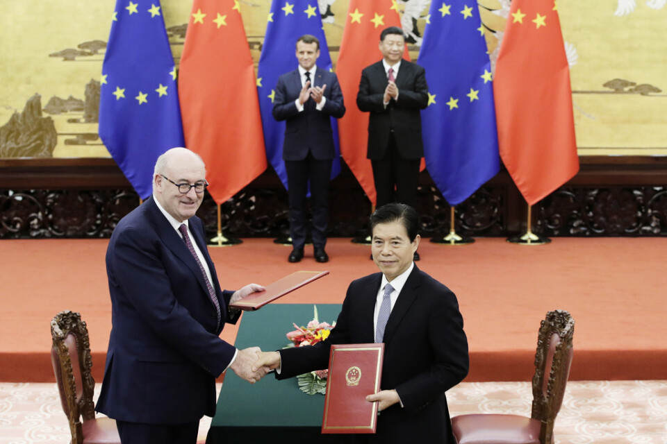EU:s jordbrukskommissionär Phil Hogan skakar hand med Kinas handelsminister Zhong Shan i Peking under pågående besök från Frankrikes president Emmanuel Macron hos Kinas Xi Jinping.
