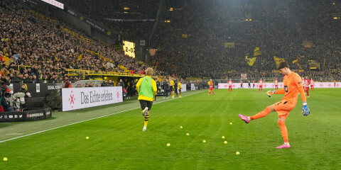 Dortmunds målvakt Gregor Kobel rensar planen på tennisbollar. Arkivbild.