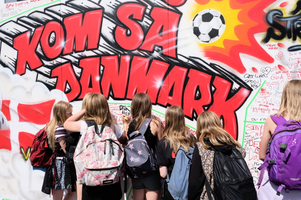 Skolbarn från Hareskov skole i Værløse besöker supporterområdet på Ofelia Plads och skriver på hälsningsväggen till landslagsspelaren Christian Eriksen, som drabbades av hjärtstillestånd under lördagens EM-match mot Finland på Parken.