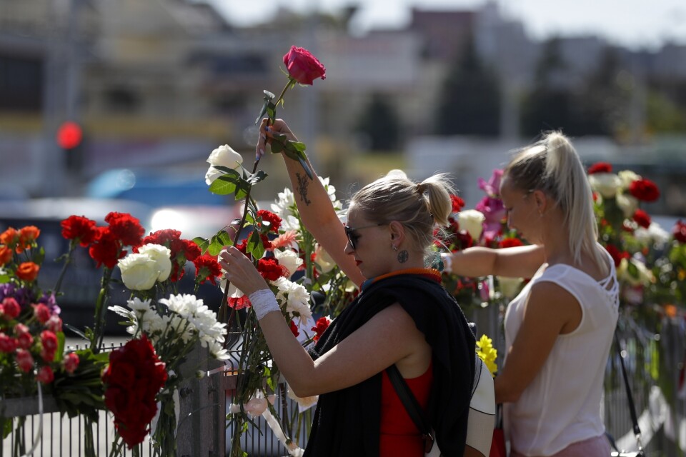 Minskbor lägger ned blommor på platsen där en oppositionsanhängare miste livet under måndagens protester.