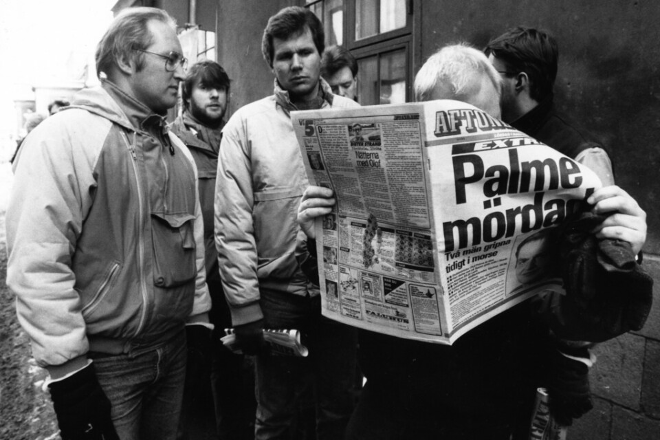 Människor läser i tidningen dagen efter mordet på statsminister Olof Palme den 28 februari 1986.