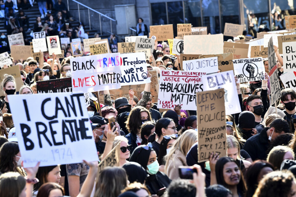 Deltagare med skyltar vid en tyst protest på Plattan, Sergels torg, i Stockholm City för att visa stöd för Black lives matter.