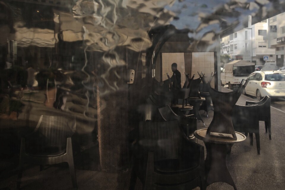 En anställd stänger ett kafé i huvudstaden Rabat i Marocko efter att regeringen utfärdat hårdare restriktioner till följd av coronaviruset.