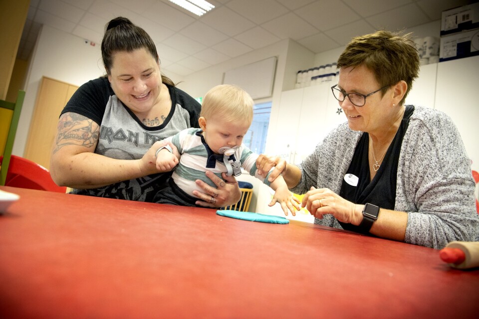 Lovisa Montan's son Eddi is going to make hand- and foot- impressions.  Preschool teacher Ing-Marie Nilsson lends a helping hand.