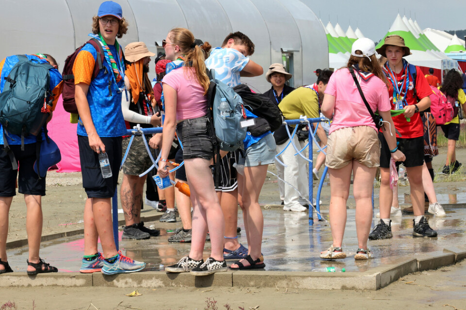 Deltagare på världsscoutjamboreen i Sydkorea svalkar sig med vatten. Många mår dåligt i hettan.