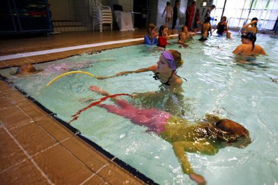 Tea Bengtsson dyker medans simlärare Karna Wiberg håller ringar.