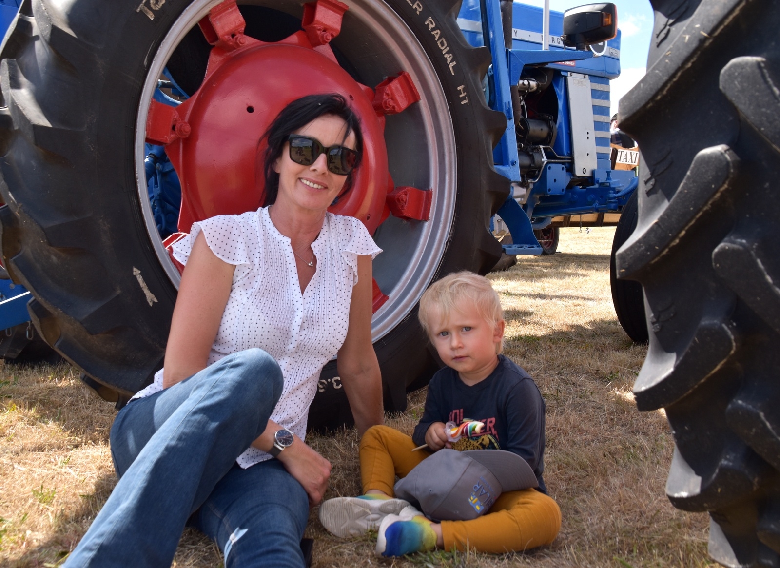 Helen Fällman och lille Elton hittade lite skugga under en traktor.