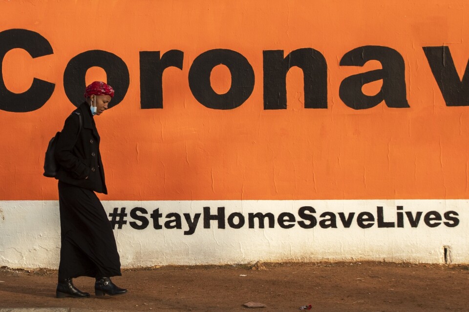 En väggmålning i sydafrikanska Soweto uppmanar människor att hålla sig hemma. Nu har landet säkrat ett nödlån för att minska coronasmällen.