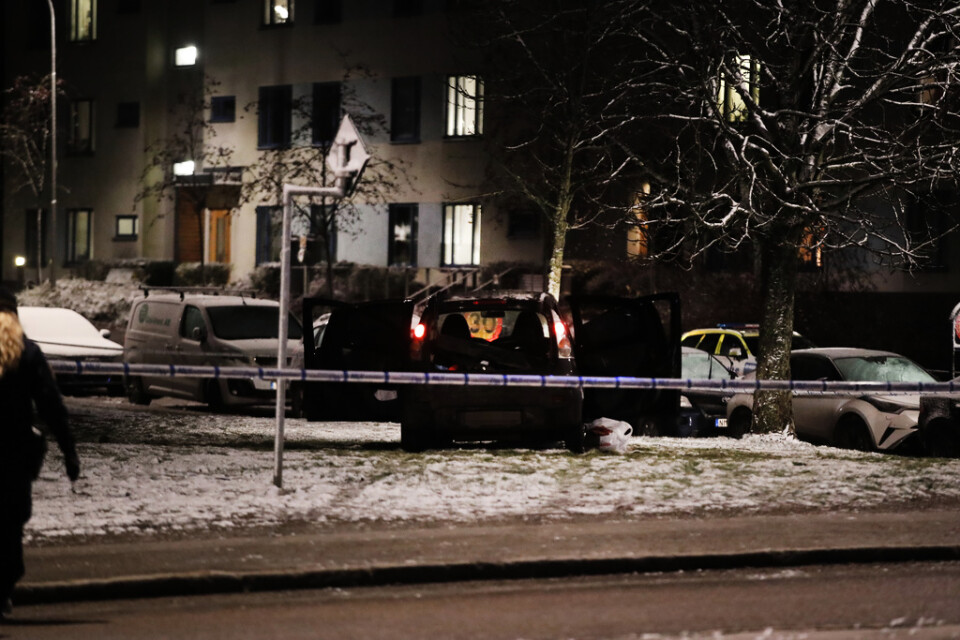 En sönderskjuten bil på platsen där två personer sköts i Rågsved.
