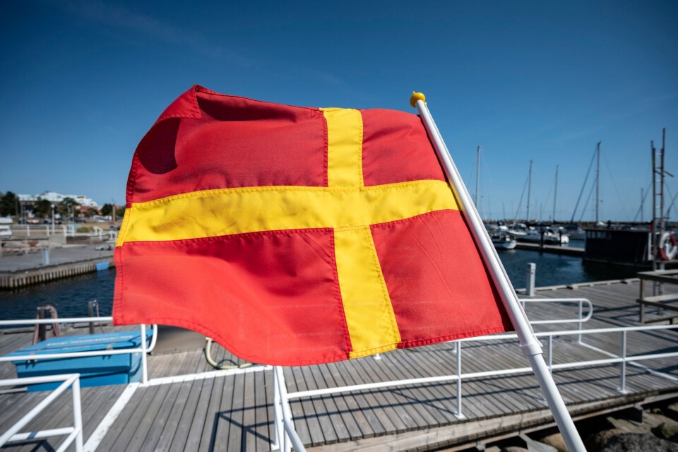 Den skånska flaggan vajar i vinden i marinan i Ystad i augustivärmen.