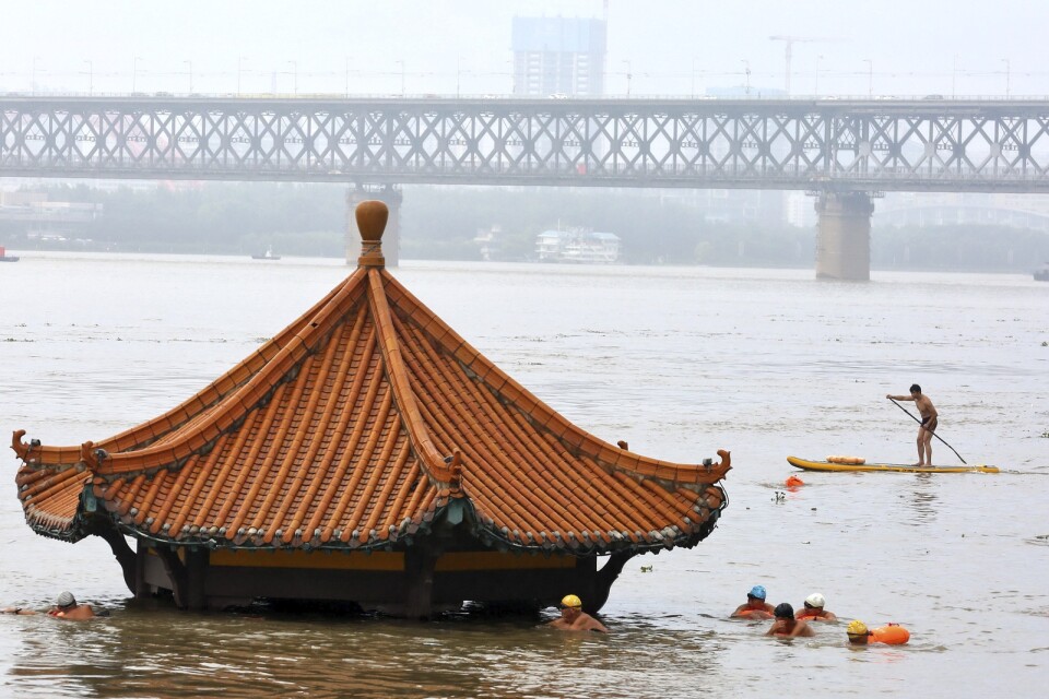 Invånare tar en simtur vid en paviljong som översvämmats vid Yangtzefloden i Wuhan i Hubeiprovinsen i förra veckan.