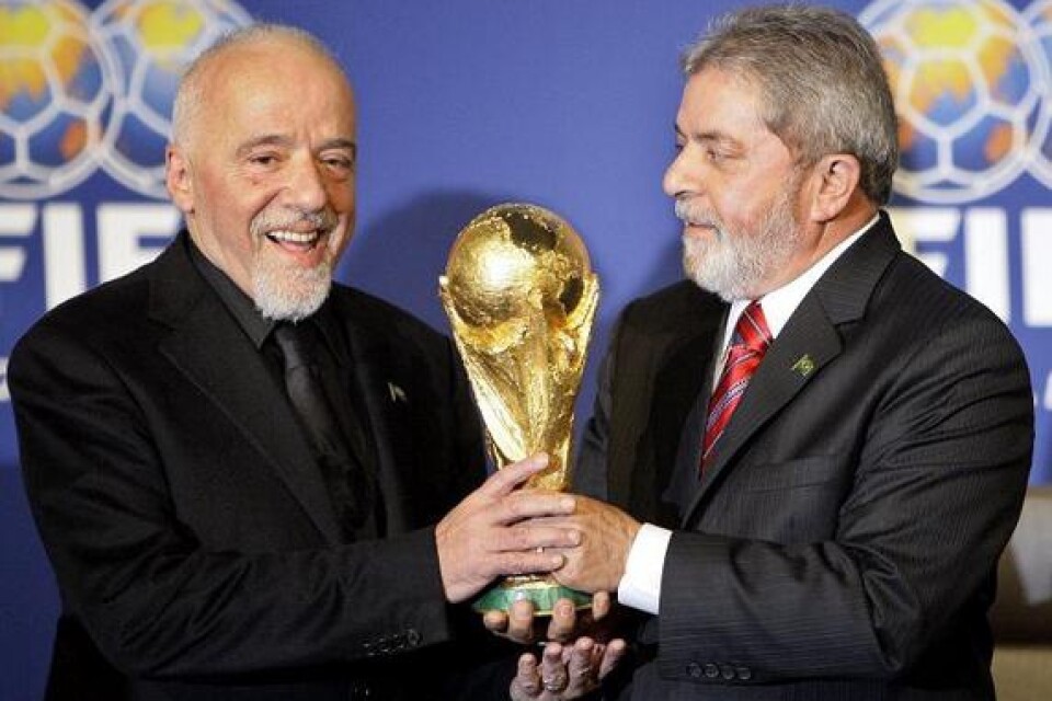 Paulo Coelho (t.v) lyfter bucklan ihop med Brasiliens president Luiz Inacio Lula da Silva, när Fifa utsett deras hemland Brasilien till VM-värd i fotboll år 2014.