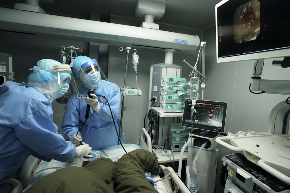 Vårdanställda i Wuhan undersöker en patient på ett fältsjukhus. Arkivbild.